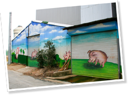 通学路沿いのシャッターにはかわいい豚のイラストが。登下校時の子どもたちの目を楽しませている。