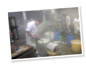 豆を蒸す圧力釜とできたての豆乳からもうもうと湯気が上がる。「この蒸気のおかげで風邪はひかないよ」と治さん。親子3人のチームワークで次々と豆腐ができあがる。